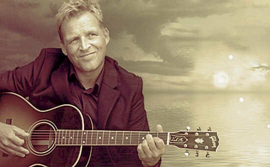Kim Schwartz med guitar i solnedgangslys